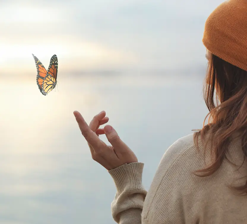Mariposa posandeso sobre el dedo de una mujer