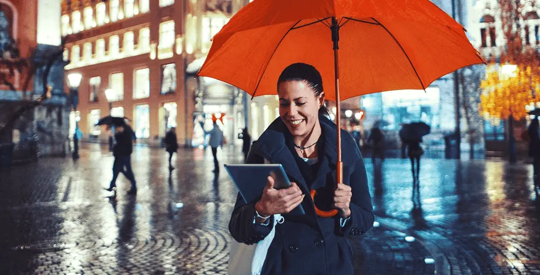 Mujer sonriendo bajo un paraguas